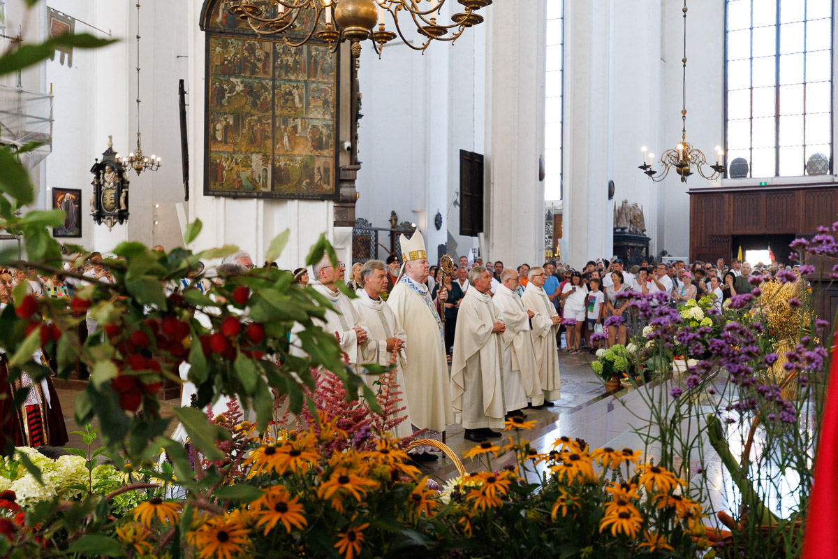 Arcybiskupi i duchowni w białych szatach liturgicznych podczas uroczystej celebracji w Bazylice Mariackiej w Gdańsku – fotoreportaż religijny.