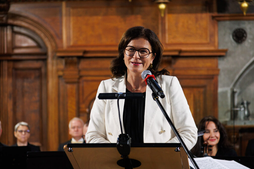 Aleksandra Dulkiewicz przemawia przy mównicy podczas uroczystości kulturalnej w Dworze Artusa w Gdańsku.
